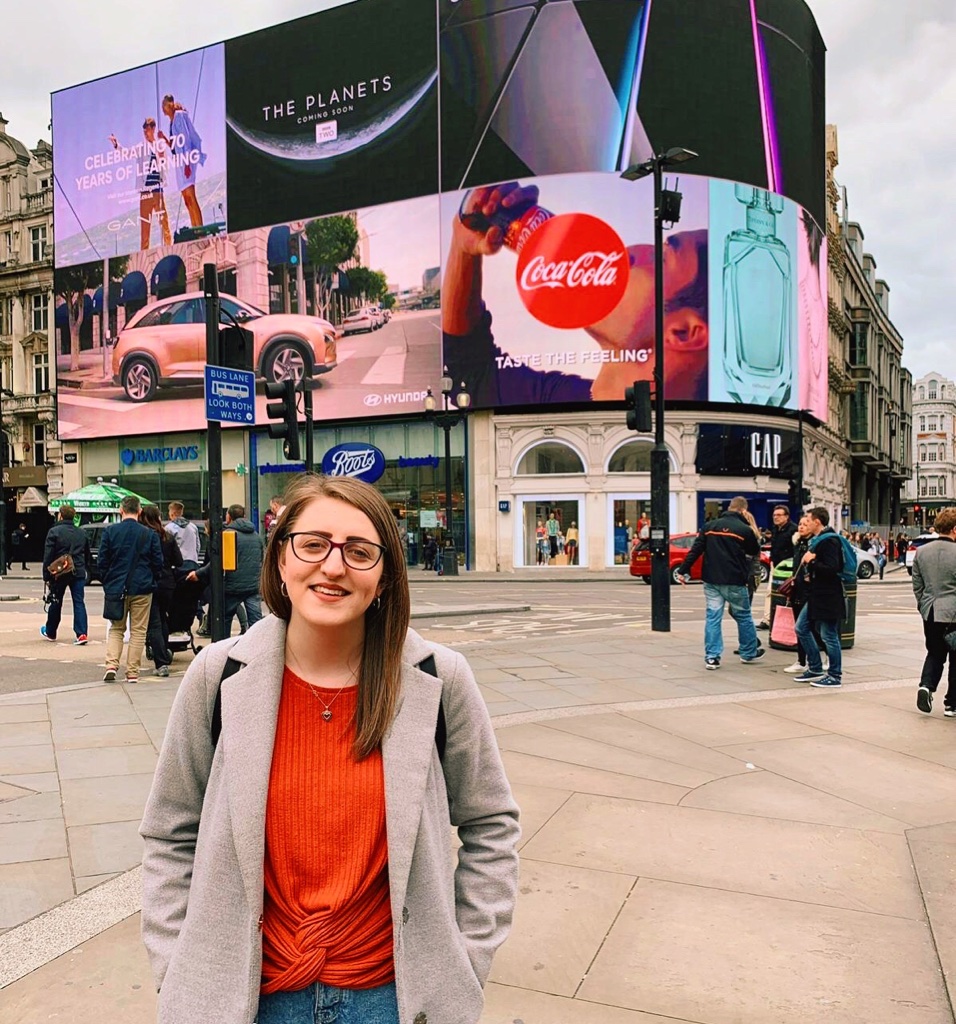A girl standing in front of Piccadilly Circus in London